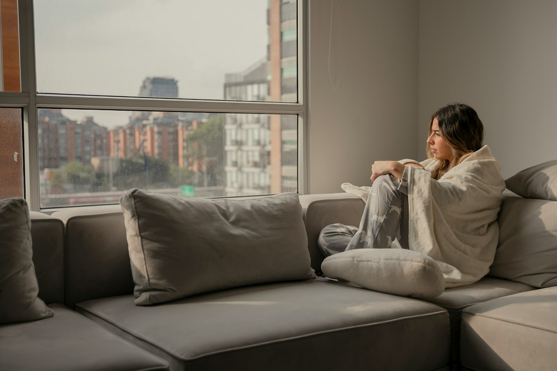 woman at home covered in blanket